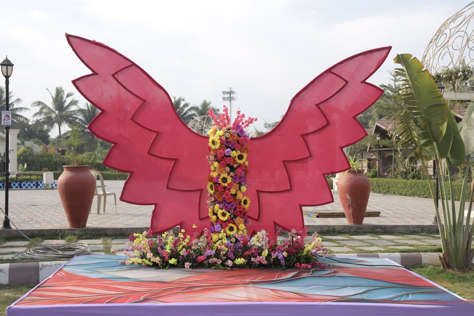 A pink butterfly art installation with fresh flowers